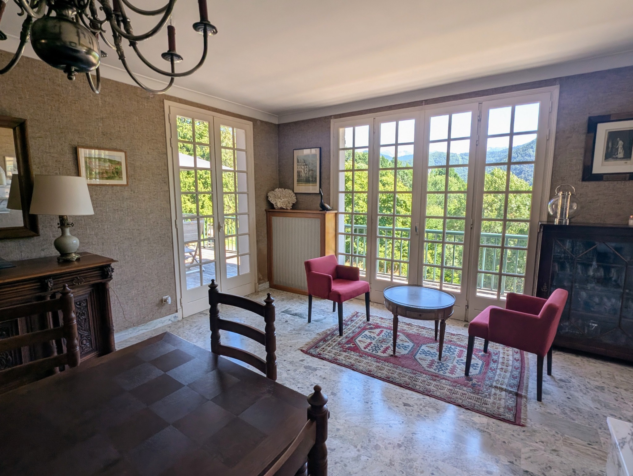 Grande pièce réunissant un petit salon et la salle à manger autour d’une grande cheminée